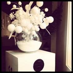 a vase filled with white flowers sitting on top of a box