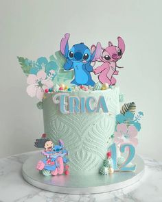 a birthday cake decorated with cartoon characters and flowers