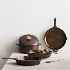 three pots and pans sitting on a counter