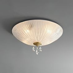 a white ceiling light with two crystal drops hanging from it's center fixture, against a gray background