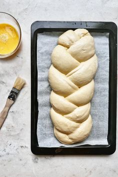 a loaf of bread sitting on top of a baking pan next to a paintbrush