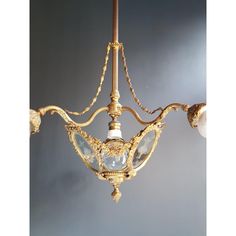 an antique chandelier hanging from the ceiling with two lights on each one side