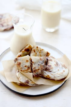 some food is sitting on a plate next to a glass of milk