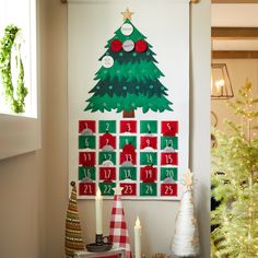 a decorated christmas tree is displayed on the wall next to other holiday decorations and candles