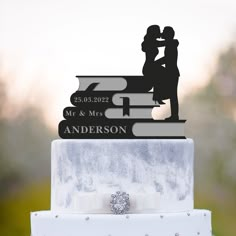 a wedding cake topper with a couple and their dog