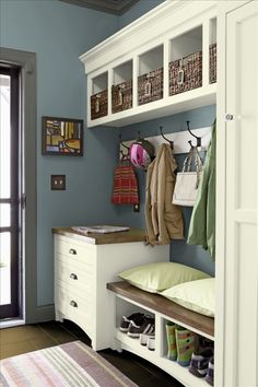 a room with some clothes hanging on the wall and other items sitting on shelves in it