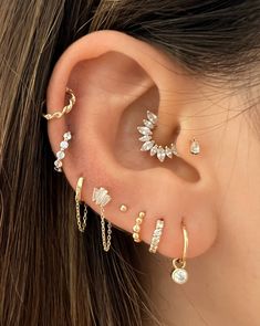 a woman's ear with four different types of piercings