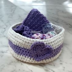 a crocheted basket is sitting on a marble counter top with a plastic bag in it