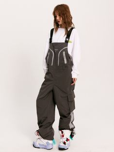 The Solaris Technical Overalls feature a wind + water-resistant nylon blend construction in a loose fit. Logo print and trim detail to the bib alongside concealed zip closure pockets. Buckle embellished shoulder straps with an adjustable waist buckle and belt loops. Cargo pockets to the legs with hardware drawcord cuffs. Rubberized logo patch to the back finished off with signature GRKC garment labels. Wind + Water Resistant Bib Overalls Buckle Shoulder Straps Cargo Pockets No Restocks Unisex Mo Cyberpunk Overalls, Overalls Reference, Subtle Poses, Unique Overalls, Mechanic Outfit, Mechanic Clothes, Cargo Overalls, Work Overalls, Architecture People