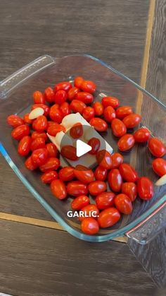 a glass bowl filled with tomatoes on top of a wooden table