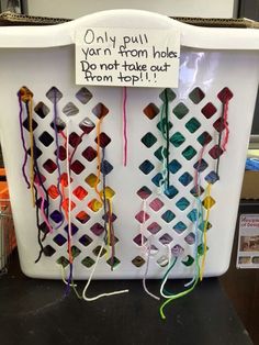 an office cubicle with several different colored crochet hooks attached to it