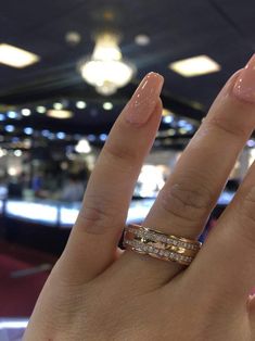 a woman's hand with two wedding bands on it and a ring in the middle