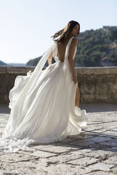 a woman in a white dress is walking