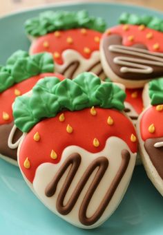 decorated cookies on a plate with forks and spoons in the shape of strawberries