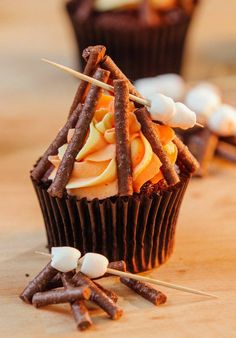 cupcakes with sticks sticking out of them on a table