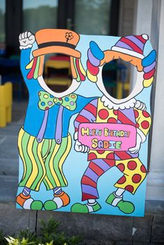 a painted sign with two clowns on it's face and the words happy birthday suite