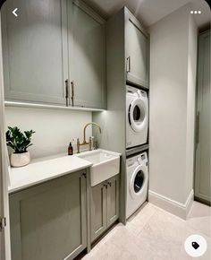 a washer and dryer in a small room with white counter tops, cabinets, and drawers