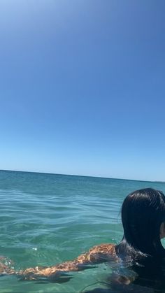 a woman swimming in the ocean on a sunny day