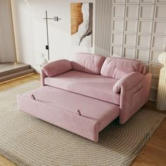 a pink couch sitting on top of a rug in a living room