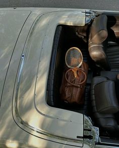 an old car with a tennis racket in the back seat