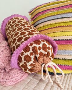 a pile of colorful knitted hats sitting on top of a white bed next to each other