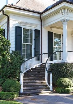 a white house with black shutters and stairs