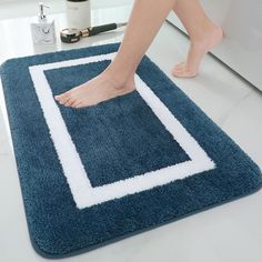 a person is standing on a blue rug with white border and foot in the middle