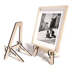 an easel and photo frame stand next to each other