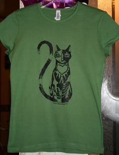 A Crowfire Creations original design! "Stripe" cat design on tanks and tees for ladies - only $15 each!  Limited edition. I fashioned this design after one of my own beloved cats, named Stripe, back in 1997.  I had it tattooed on my right upper arm at that time, as well.  It was one of my first.  Everywhere I go, people tell me how much they love my cat tattoos, even those who are not into tattoos.  They just can't resist!  Now you can't either, can you? "Stripe" cat design screen printed by Elg Fitted Cat Print Graphic Tee, Fitted Cat Print Graphic Tee T-shirt, Striped Cat, Leaf Coloring, Ladies T Shirt, Color Shorts, Cat Tattoo, Cat Design, Soft Style