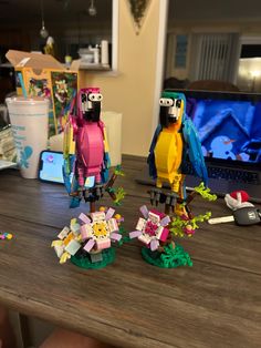 two lego birds sitting on top of a wooden table