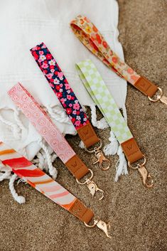 four different colored lanyards are laying on the ground next to a white towel