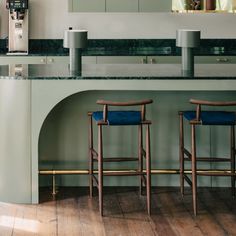 two bar stools sitting in front of a counter