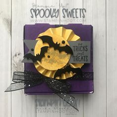 a purple and yellow halloween card with bats on the front, black ribbon around it