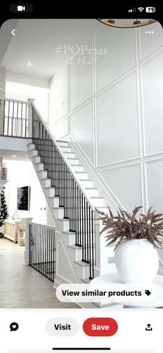 an image of a white staircase with black railings on the bottom and second story