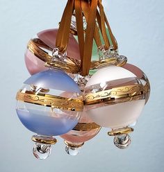 an ornament hanging from the ceiling with three different colored ornaments attached to it