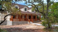 the house is surrounded by trees and dirt