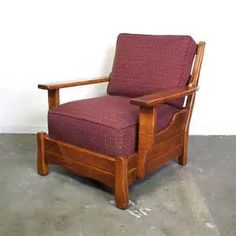 a chair that is sitting in the middle of a room with concrete flooring and white walls