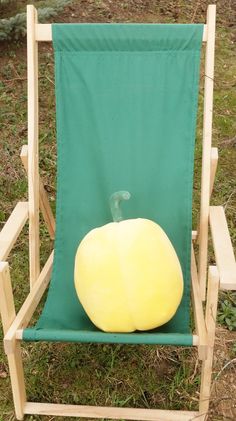 a green lawn chair with a yellow ball on it