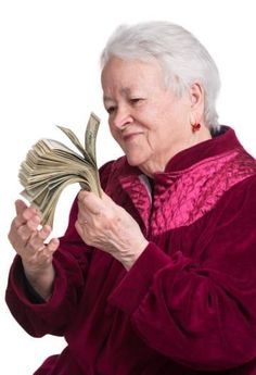 an elderly woman holding money and looking at it