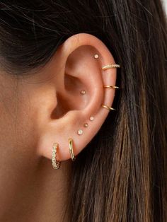 a woman's ear with three different types of piercings