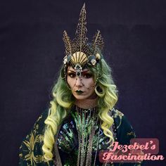 Andrina - A majestic mermaid headdress comprised of deep metallic green shells trimmed and adorned with gold as well as golden seashells accented with dark green rhinestones with a central sparkling emerald green pendant and tall spikes of golden coral type sea spikes finished off with coordinating twinkling green and gold stone face chains. A spectacular finishing touch for your mystical deep sea mermaid! Pair with my Neptunia dressing gown for a complete costume! Under The Sea Body Adornment, Sea Monster Costume, Ocean Inspired Headpiece, Face Chains, Siren Crown, Siren Photoshoot, Festival Goddess, Crown Emerald, Siren Headdress