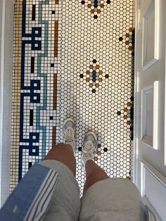 a person standing in front of a door with their feet up on the door mat