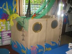 a cardboard boat made to look like an ocean scene with fish and seaweed on it