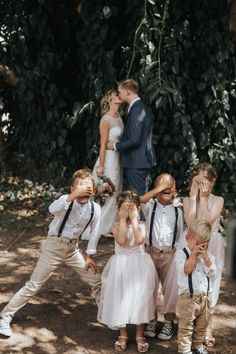 a group of children standing next to each other in front of a man and woman