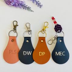 four leather keychains with the letters dw, dp and mec on them