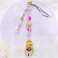 an anime character keychain hanging from a string with beads and charms on it