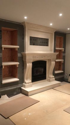 a room with some shelves and a fire place in the middle of it that is being built