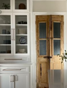 a kitchen with white cabinets and wood floors