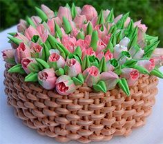 there is a small basket with flowers in it on the table outside and green grass