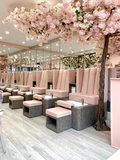 a salon with pink chairs and flowers on the ceiling, mirrors in the wall behind them